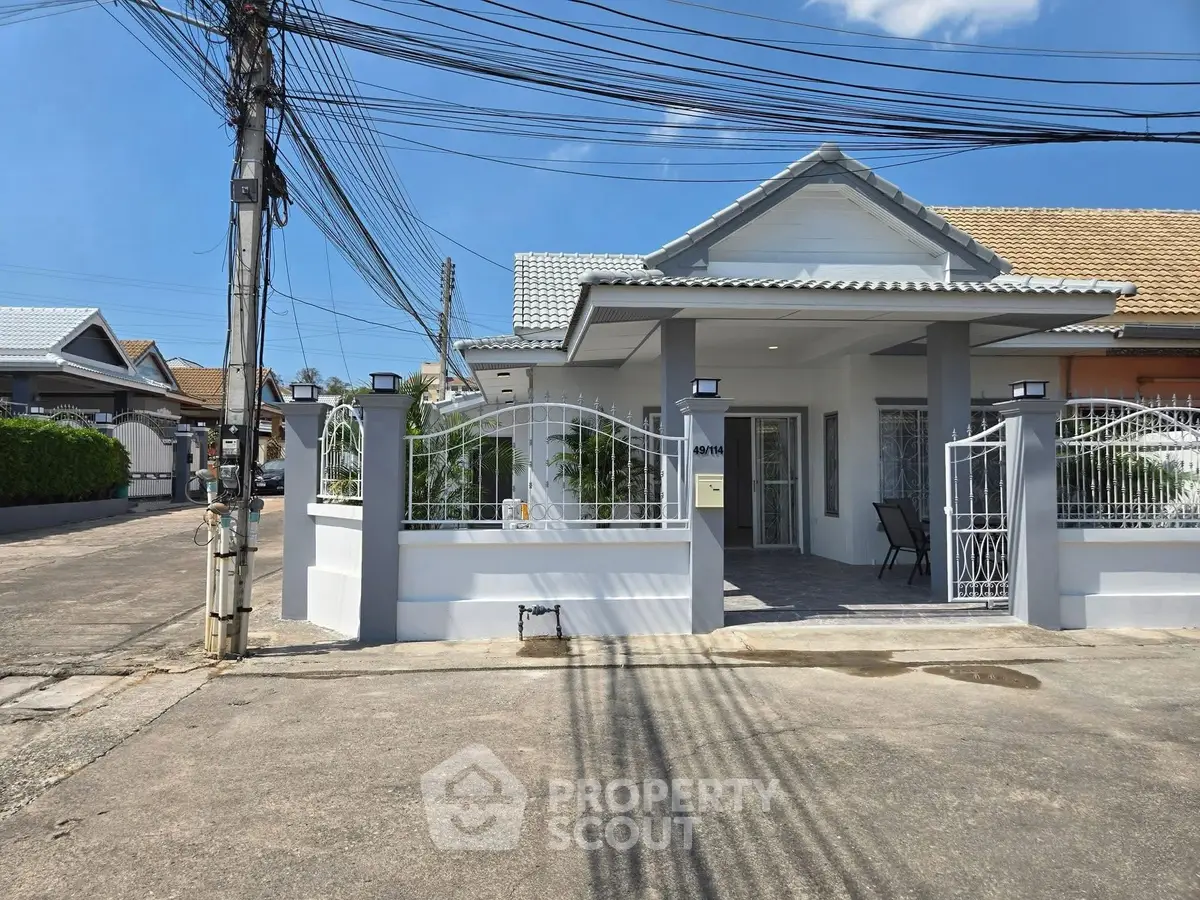 Charming single-story house with gated entrance and modern exterior design in a peaceful neighborhood.