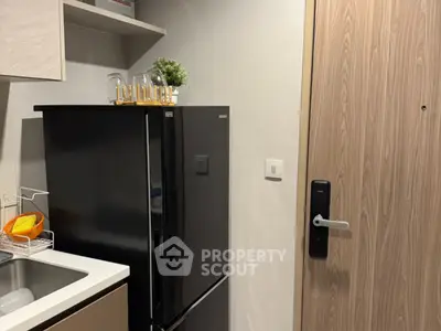 Modern kitchen with sleek black fridge and digital door lock