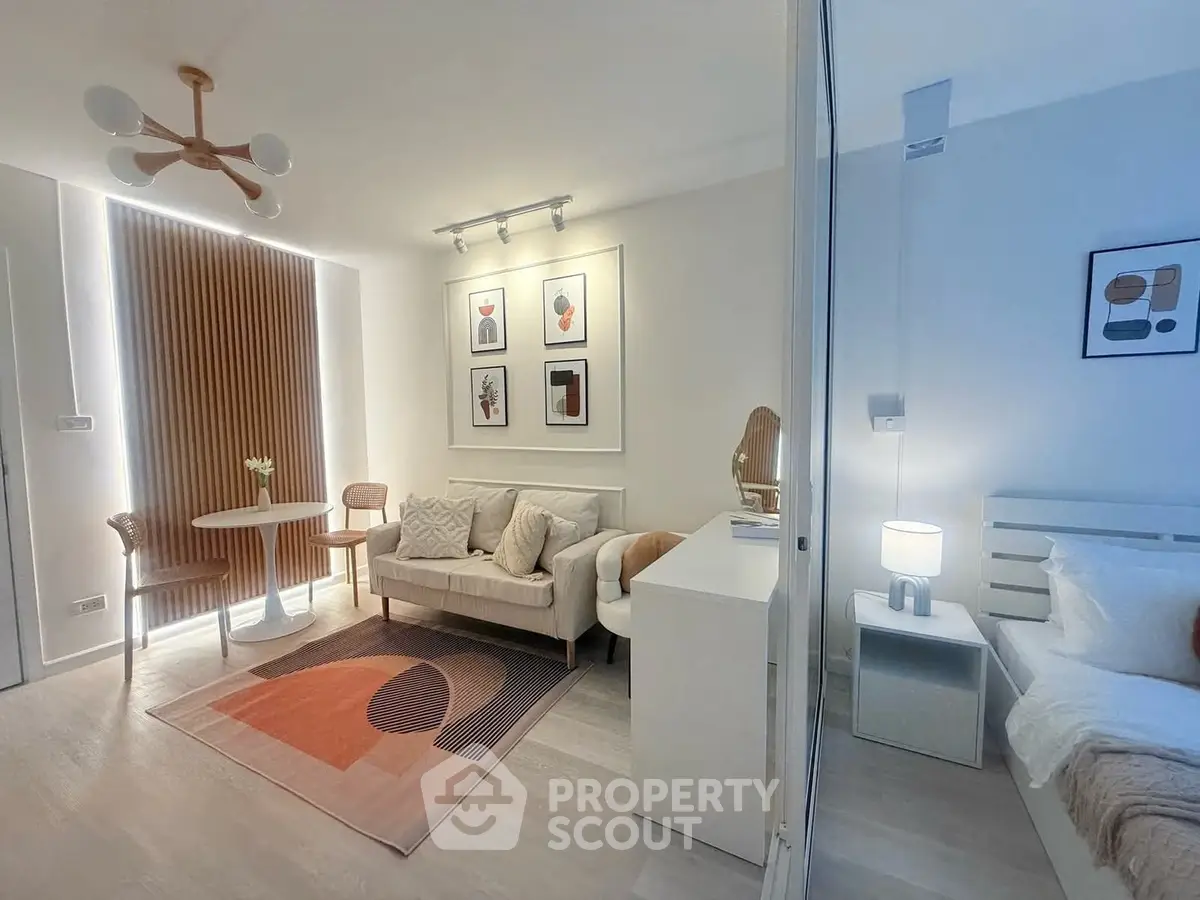 Modern living room with stylish decor and adjacent bedroom in open-plan apartment.