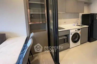 Modern kitchen with sleek appliances and dining area in stylish apartment