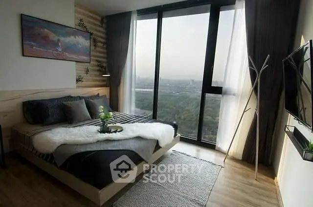 Modern bedroom with large windows offering stunning city views, stylish decor, and cozy ambiance.