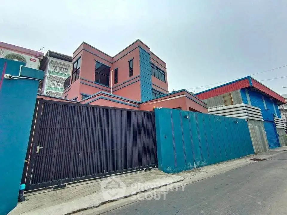 Modern two-story building with vibrant colors and secure gated entrance.