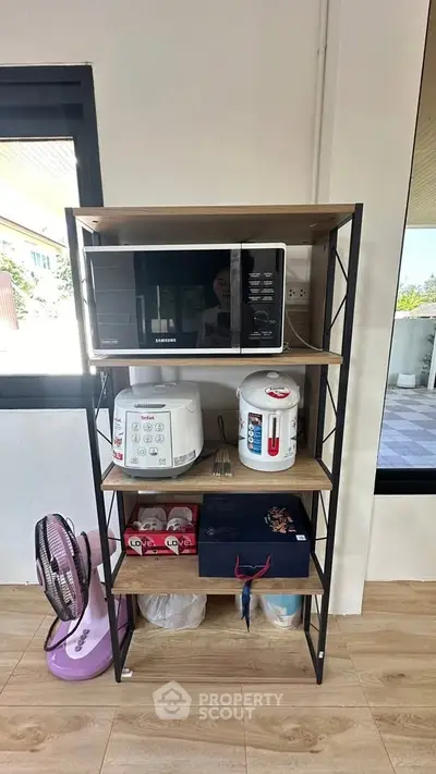 Modern kitchen shelf with microwave and appliances in bright interior