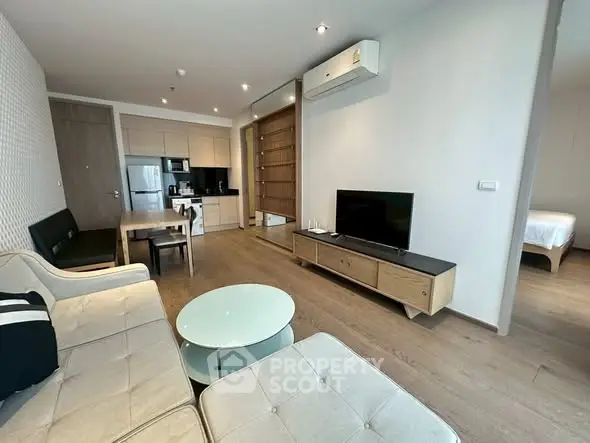 Modern living room with open kitchen and stylish furniture in a cozy apartment.