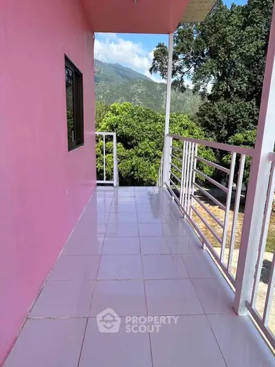 Charming balcony with scenic mountain views and vibrant pink walls, perfect for relaxation.