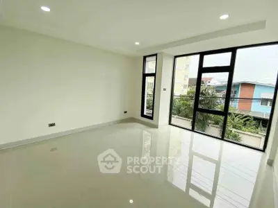 Spacious modern living room with large windows and glossy tiled floors