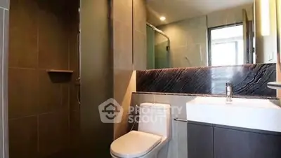 Modern bathroom with sleek design and spacious shower area in a contemporary apartment.