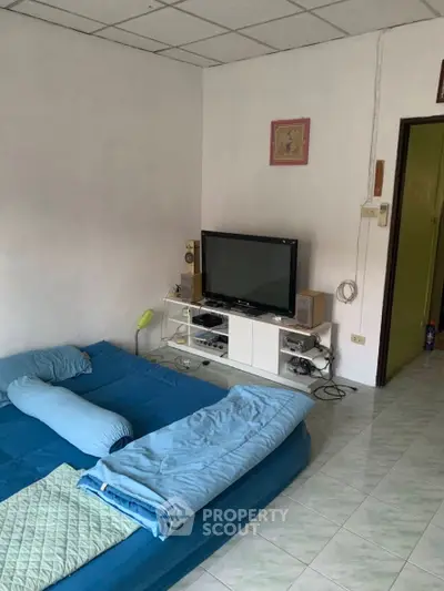 Cozy living room with TV and floor mattress, ideal for relaxation.
