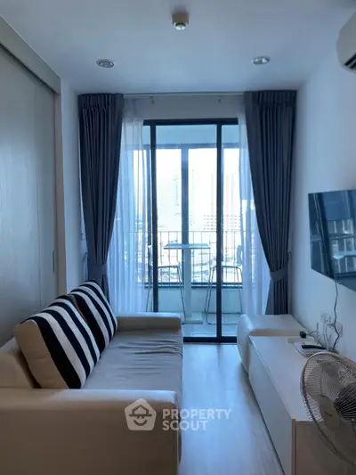 Modern living room with balcony view, sleek furniture, and natural light.