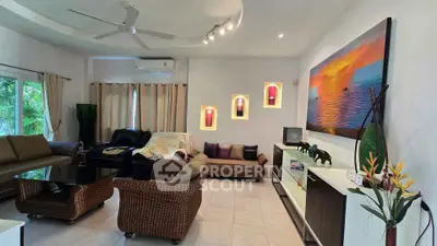 Spacious living room with elegant decor and natural light, featuring modern furniture and vibrant artwork.