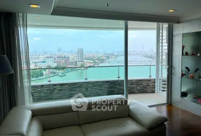 Luxurious living room with stunning river view from a high-rise balcony, featuring elegant decor and modern furnishings.