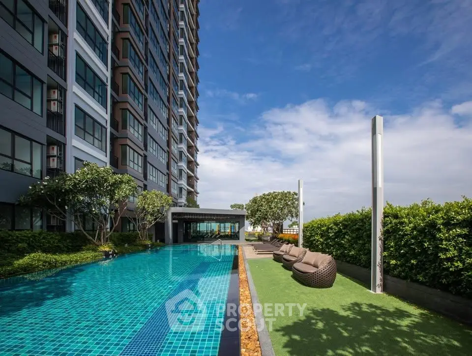 Luxurious high-rise building with stunning pool and lush greenery, perfect for modern living.