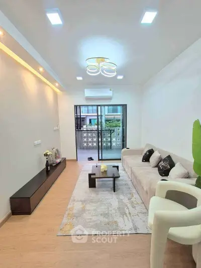 Modern living room with stylish decor and balcony view, featuring cozy seating and elegant lighting.