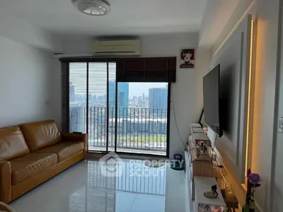 Modern living room with city view, leather sofa, and wall-mounted TV in a high-rise apartment.