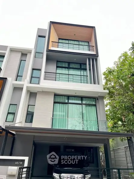 Modern multi-story townhouse with sleek design and large windows in urban setting.