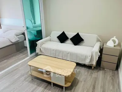 Modern living room with cozy sofa and stylish decor adjacent to a bedroom.