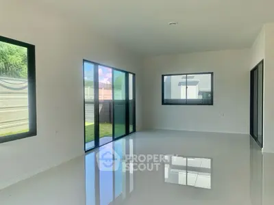 Spacious modern living room with large windows and glossy floors