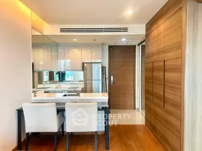 Modern kitchen with sleek design, wooden accents, and dining area in a stylish apartment.