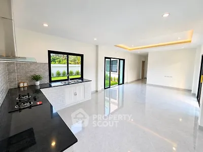 Spacious open-plan kitchen and living area with modern finishes and garden view.