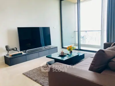 Modern living room with large TV and balcony view in luxury apartment.