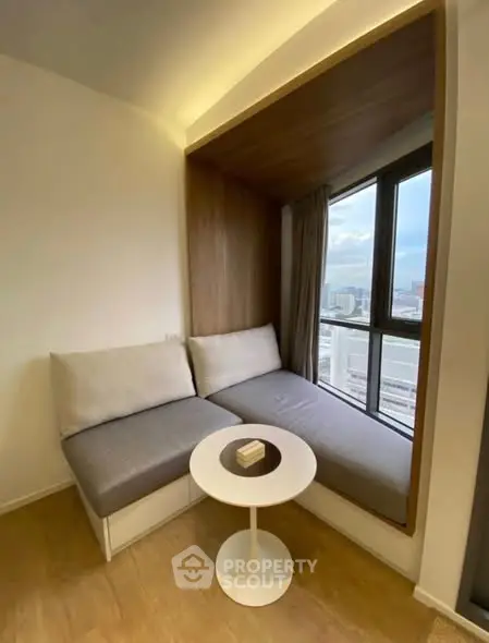Cozy window nook with seating and city view, perfect for relaxation in modern apartment.