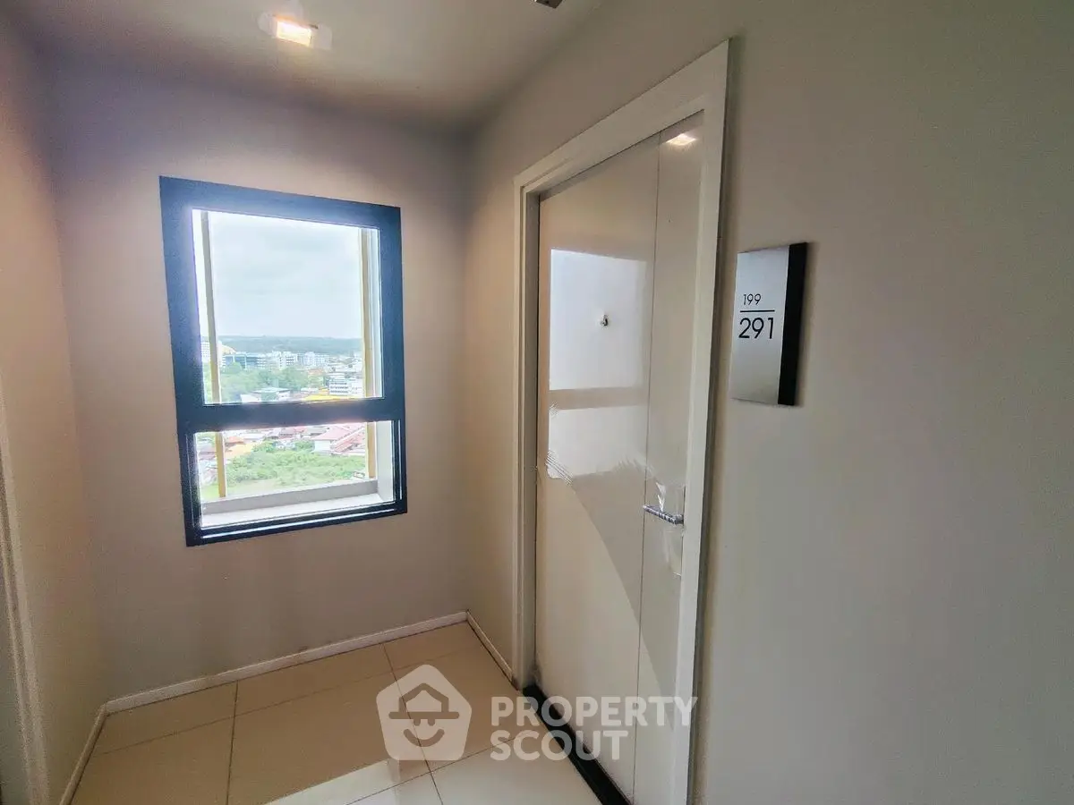 Modern apartment entrance with window view and sleek door design.