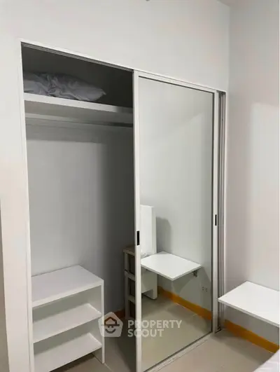 Modern minimalist closet with sliding mirror doors and built-in shelves