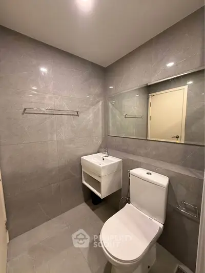 Modern bathroom with sleek gray tiles and compact fixtures