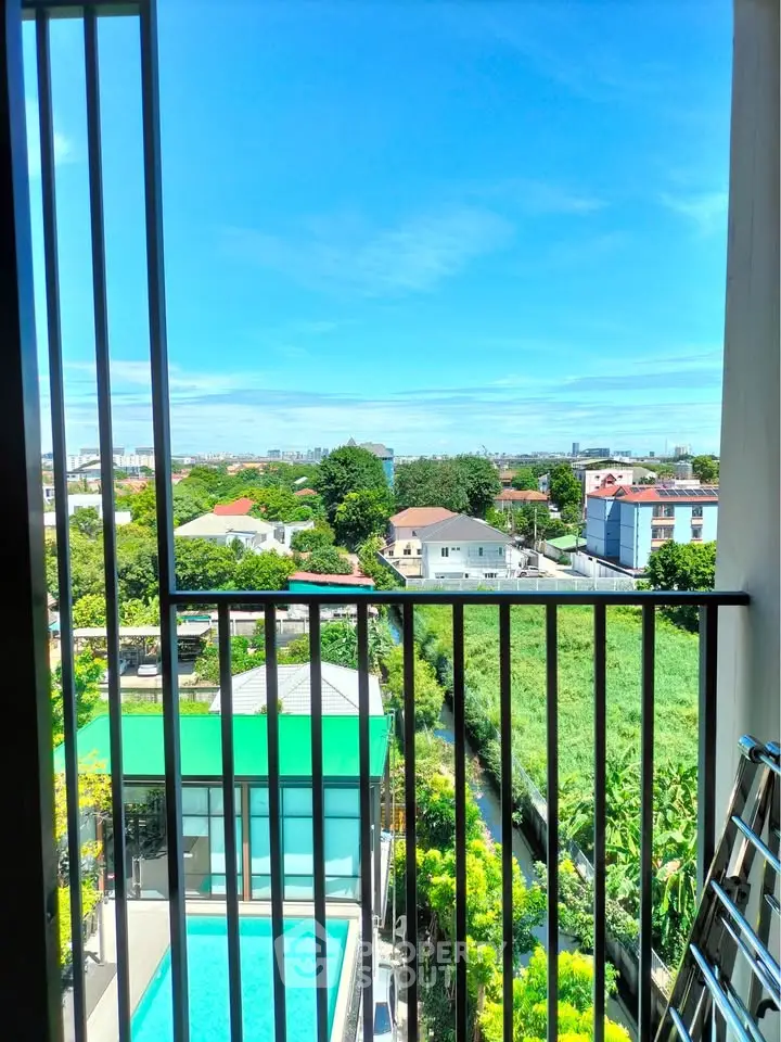 Stunning balcony view overlooking pool and lush greenery in modern residential area.