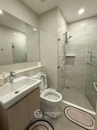 Modern bathroom with glass shower and sleek fixtures in a contemporary home.