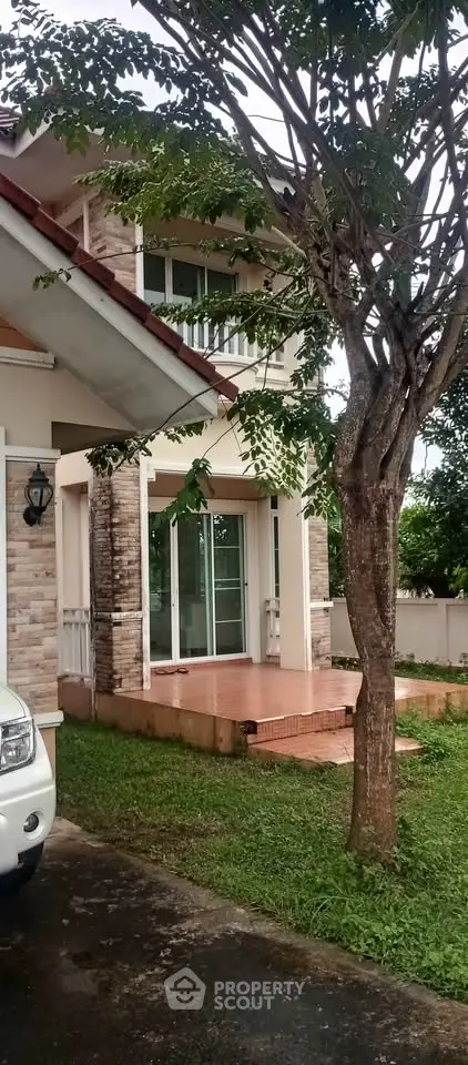 Charming two-story house with lush garden and spacious driveway, perfect for family living.