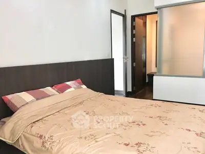 Cozy bedroom with modern decor and floral bedding, featuring a sleek headboard and soft lighting.