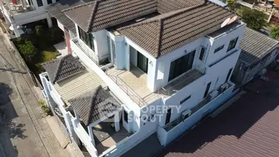 Stunning aerial view of a modern multi-level home with spacious balconies and tiled roof.