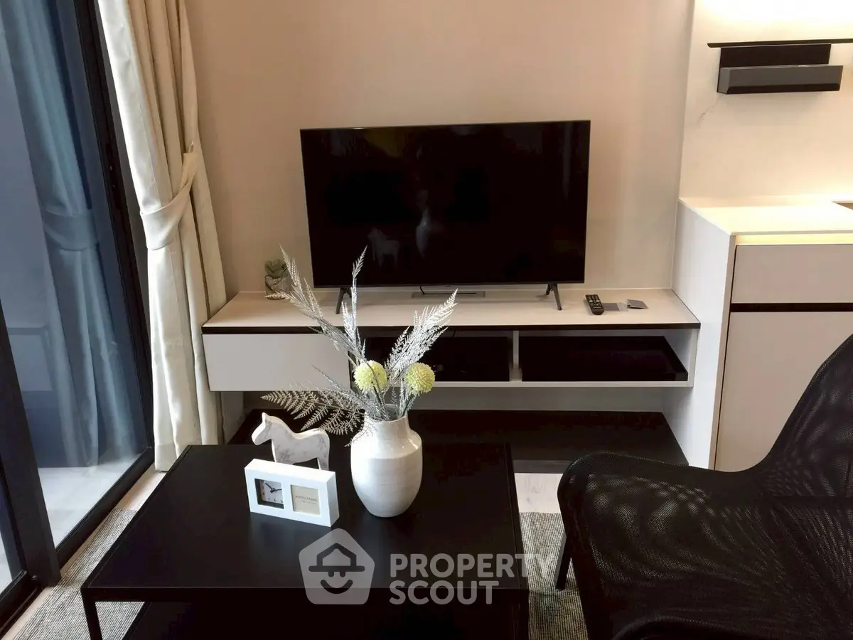 Modern living room with sleek TV setup and stylish decor in a contemporary apartment.