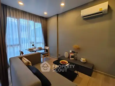 Modern living room with cozy sofa and dining area, featuring elegant decor and ambient lighting.