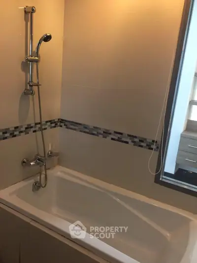 Modern bathroom with sleek bathtub and stylish shower fixtures.