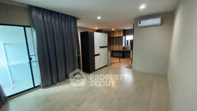 Spacious modern living room with sleek wooden flooring and large windows