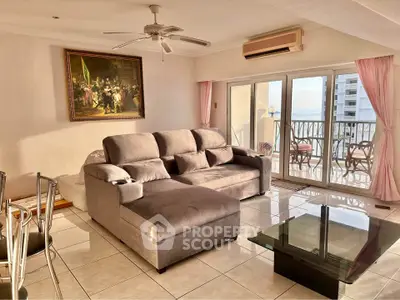 Spacious living room with modern sofa and balcony view, perfect for relaxation.