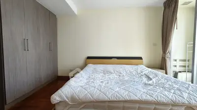 Spacious bedroom with modern wardrobe and cozy bed in a stylish apartment.