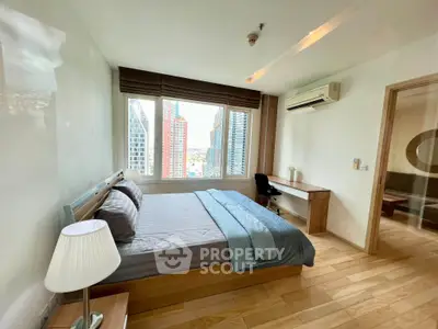 Spacious bedroom with city view in modern high-rise apartment