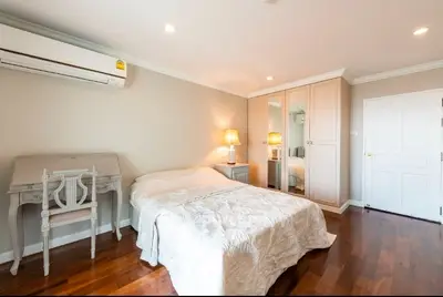 Spacious bedroom with elegant decor and wooden flooring
