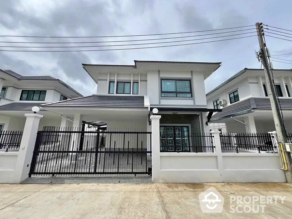 Modern two-story house with gated driveway and contemporary design