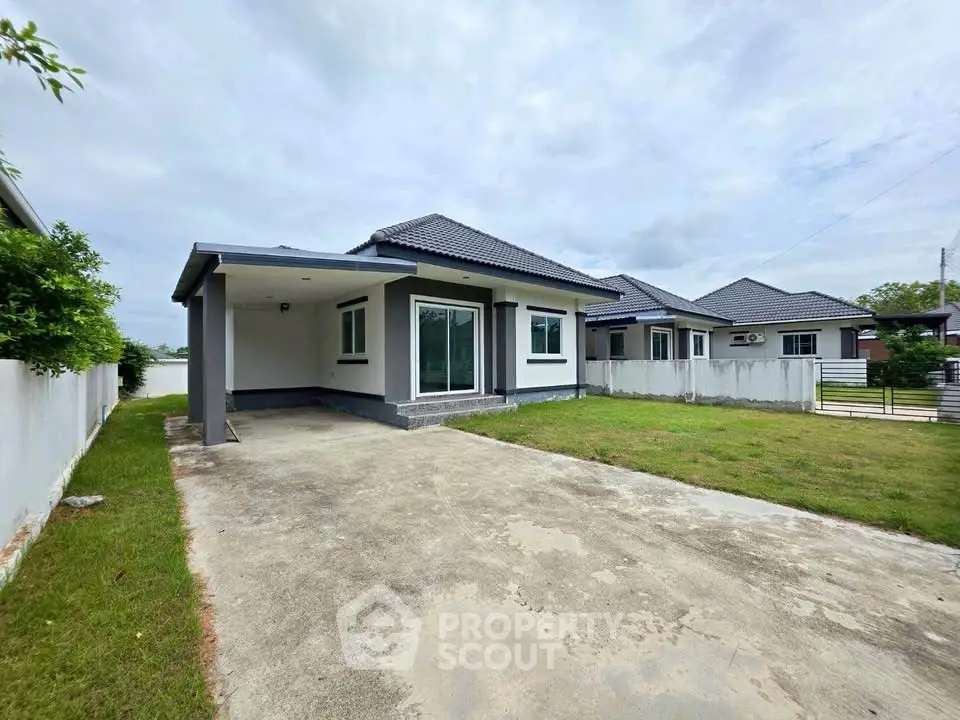 Charming single-story home with spacious driveway and lush green lawn, perfect for family living.