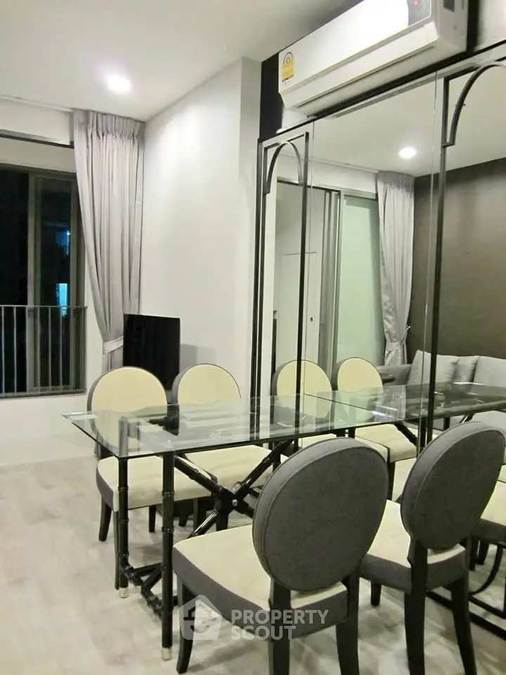 Modern dining area with glass table and elegant chairs in a stylish apartment.