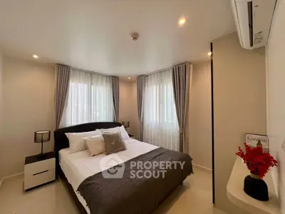 Modern bedroom with elegant decor and natural light, featuring a cozy bed and stylish curtains.