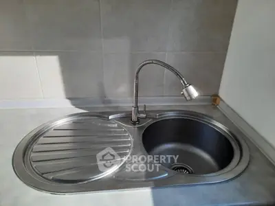 Modern kitchen sink with sleek stainless steel design and functional faucet