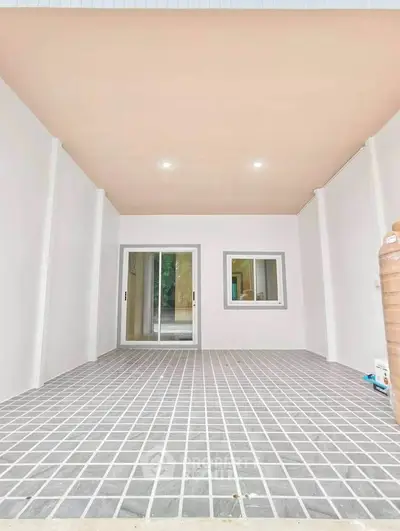 Spacious covered patio with modern sliding glass doors and tiled flooring, perfect for outdoor relaxation.