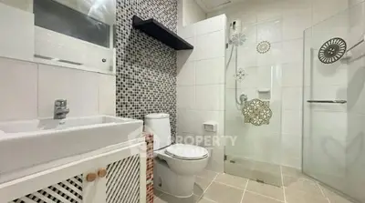 Modern bathroom with stylish glass shower and mosaic tiles