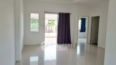Spacious unfurnished living room with large windows and tiled floor, perfect for customization.