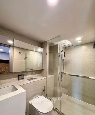 Modern bathroom with glass shower and sleek fixtures in a contemporary apartment.
